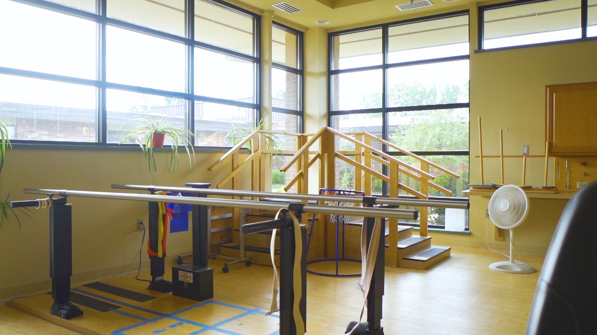 Gym with parallel bars and therapy ladder.